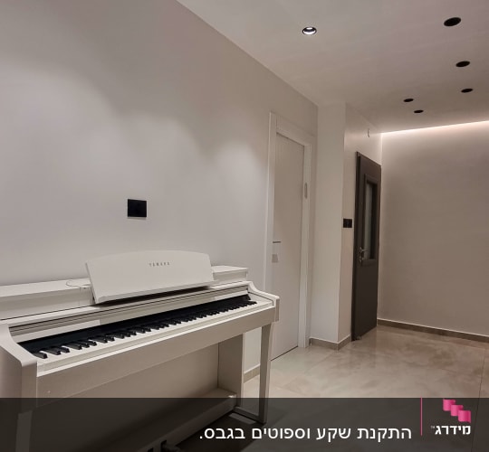 Ceiling with recessed spotlights and light switches on wall